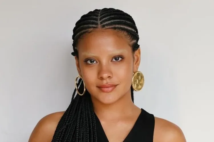Foto da atriz Bella Campos com tranças no cabelo e sobrancelha descolorida