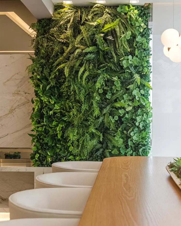 Parede verde natural com mesa e cadeiras em frente
