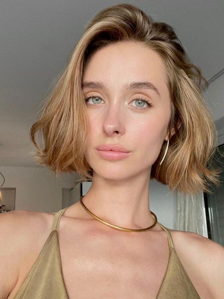 Mulher com cabelo loiro curto e repicado próximo aos ombros