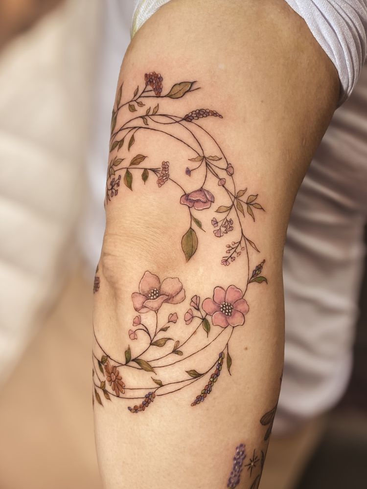 Cotovelo tatuado com ramos e flores rosas