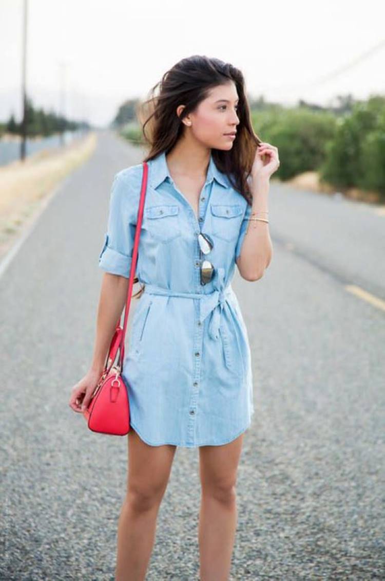 Mulher de pele clara com vestido curto jeans, bolsa rosa