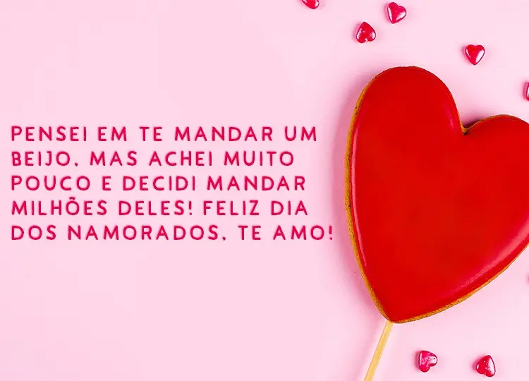 Cartão virtual de fundo rosa com grande coração vermelho e alguns pequenos, além de frase "Pensei em te mandar um beijo. Mas achei muito pouco e decidi mandar milhões deles. Feliz Dia dos Namorados. Te amo!"