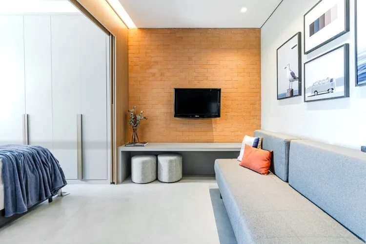 Foto de sala de kitnet de 33 m² decorada com parede de tijolinhos