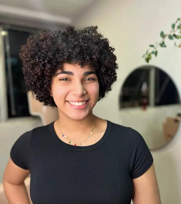 Corte curto com franja mulher cabelo castanho escuro cacheado