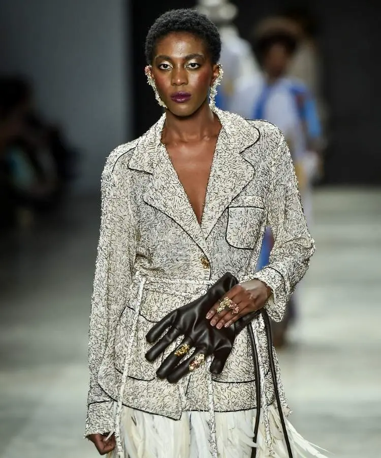 Foto de modelo segurando bolsa de couro preta em formato de mão