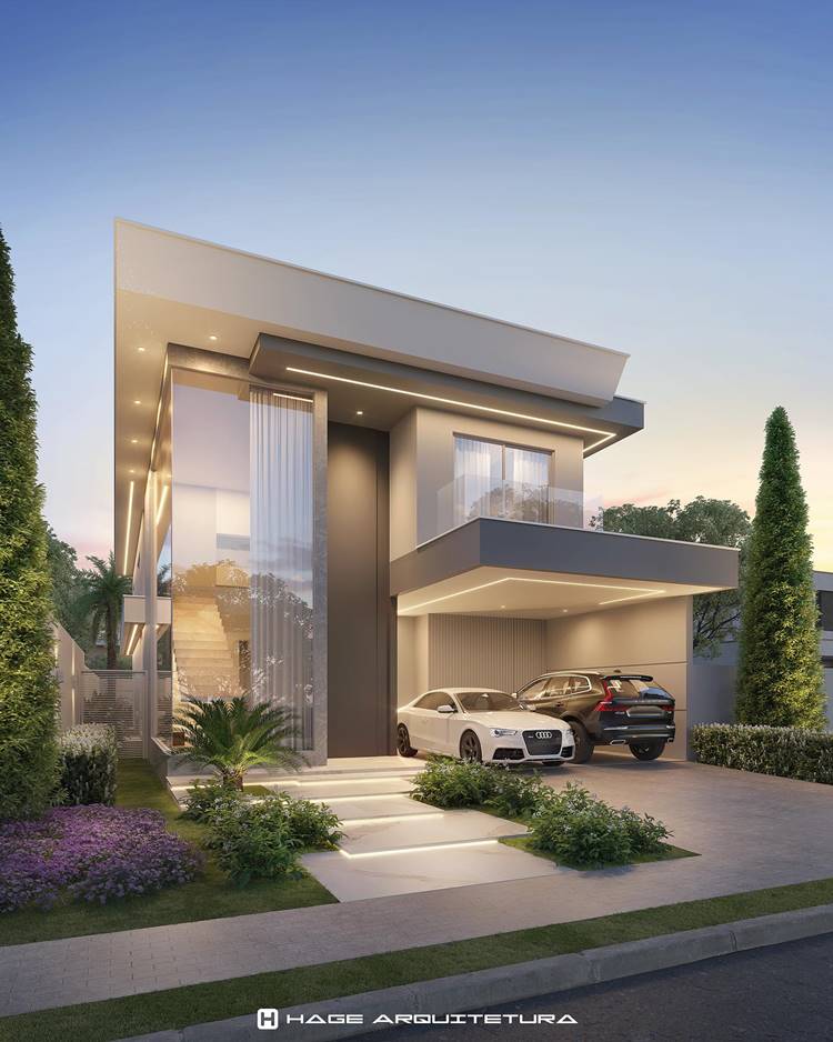 Fachada de casa moderna, com linhas retas e limpas, grandes janelas de vidro e uma garagem para dois carros. A casa tem um design minimalista com cores neutras. A frente da casa é bem cuidada com grama, arbustos e árvores altas criando simetria. A iluminação externa ilumina a fachada da casa, realçando seus detalhes arquitetônicos.