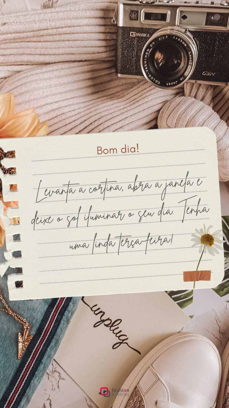 Foto de folha de caderno com frase "Levanta a cortina, abra a janela e deixe o sol iluminar o seu dia. Tenha uma linda terça-feira!", margarida e tênis