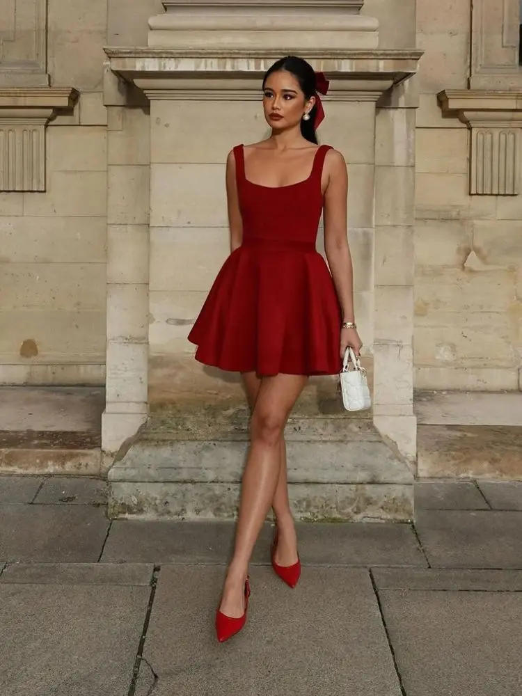 mulher usando laço vermelho, vestido rodado, bolsa branca e sapatilha vermelha, look de Natal