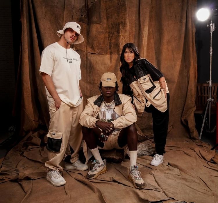 Foto de 3 modelos usando roupas com modelagem oversized: camiseta, casaco, bermuda e calça