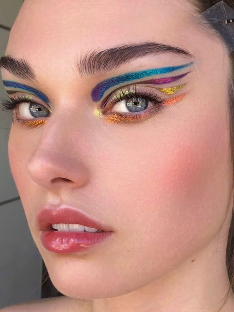 Mulher de pele clara usando delineados metalizados coloridos 