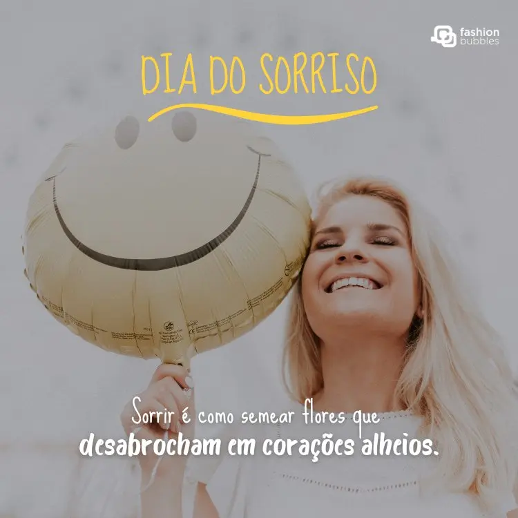 Mulher de pele clara sorrindo, segurando balão de smile face, além de frase: Sorrir é como semear flores que desabrocham em corações alheios.