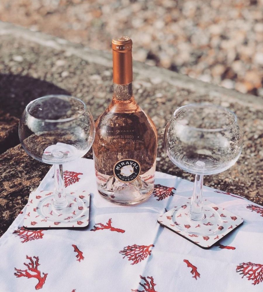 garrafa de vinho rosé Miraval em superfície de pedra ao lado de duas taças de vidro