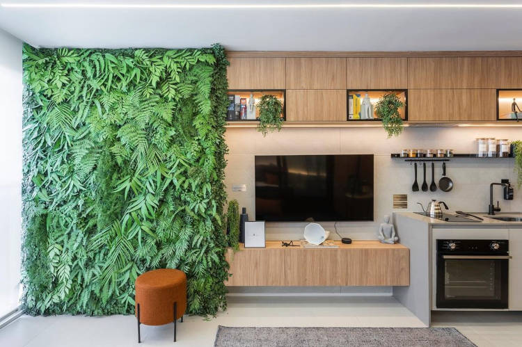Sala com jardim vertical ao lado do painel da tv.