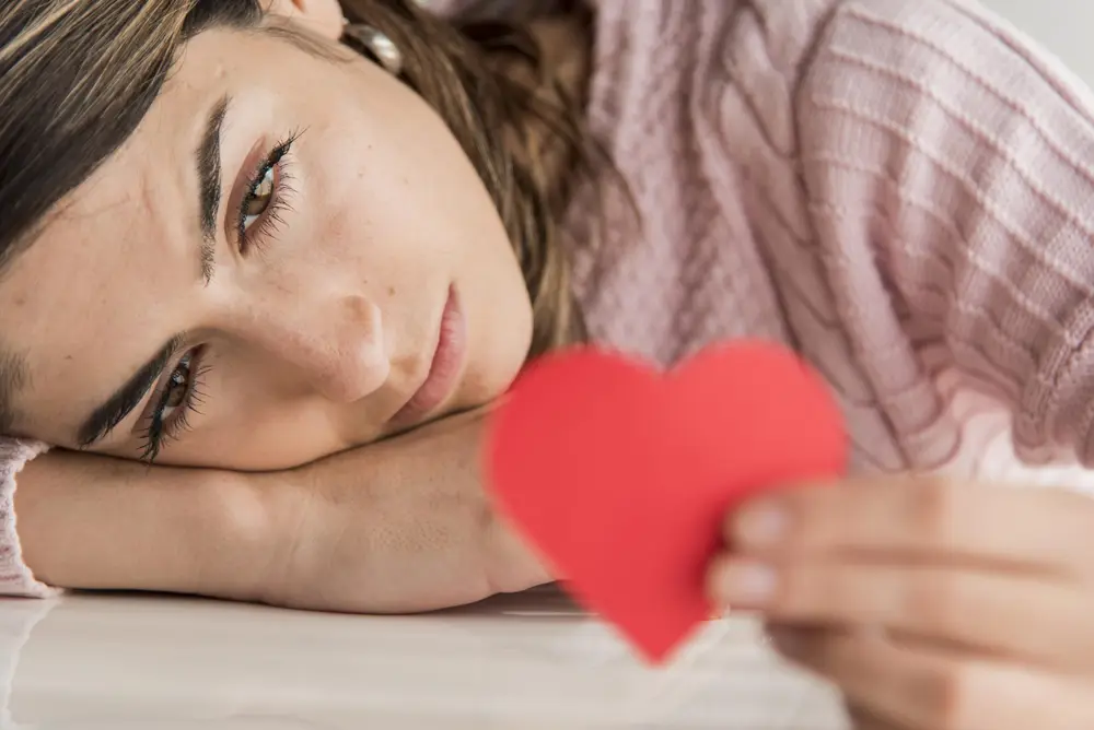 mulher triste com coração de papel na mão mulher triste com coração de papel na mão