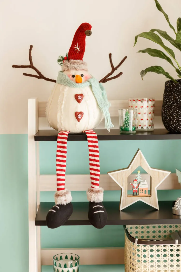 Natal renovado com enfeite de boneco de natal. Boneco em prateleira.