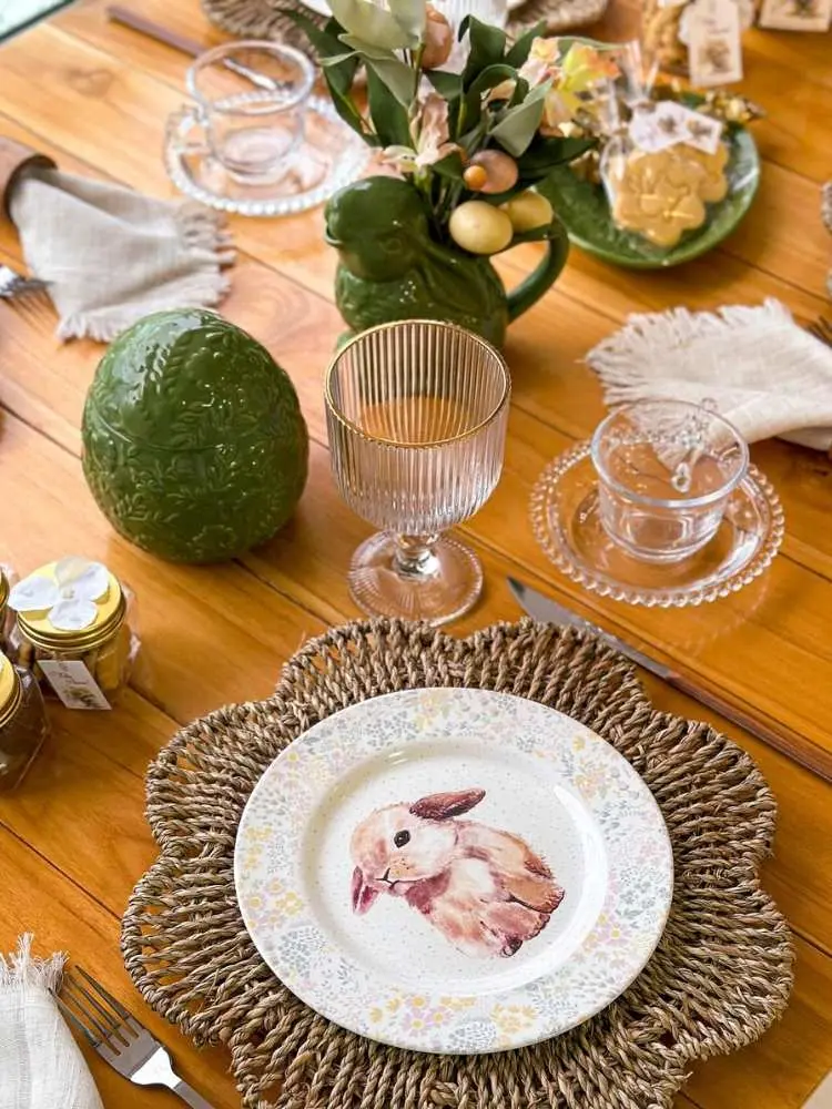 Mesa posta com sousplat de palha e prato de coelho 