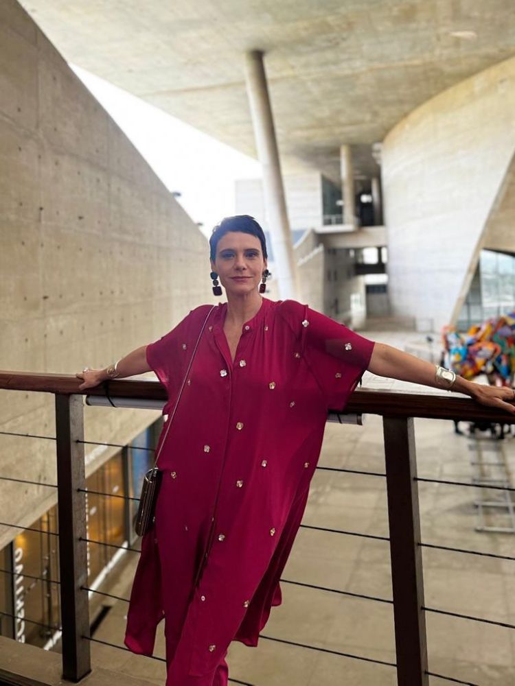 Malu Galli usando macacão maxi fluido vermelho com pedrarias