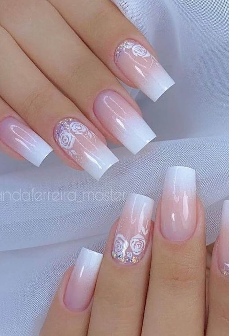 Unhas quadradas grandes com efeito babyboomer e desenho de flores brancas no anelar