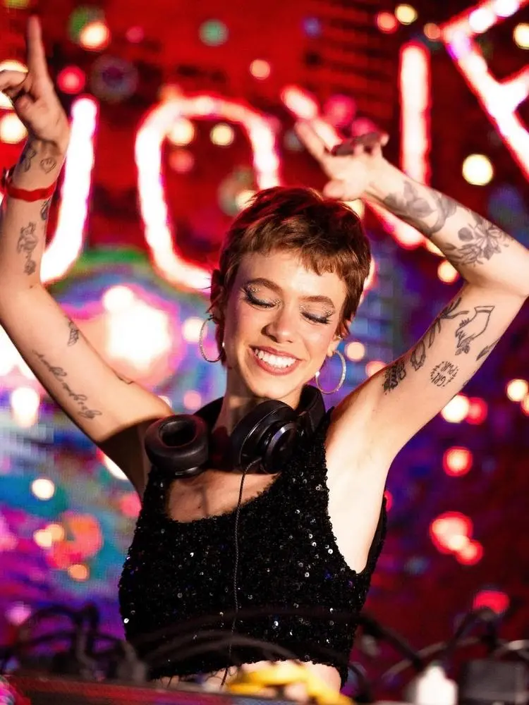 Mari Krüger de top preto tocando como DJ
