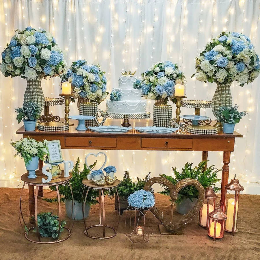 Decoração de casamento simples azul com flores na mesa e no chão.