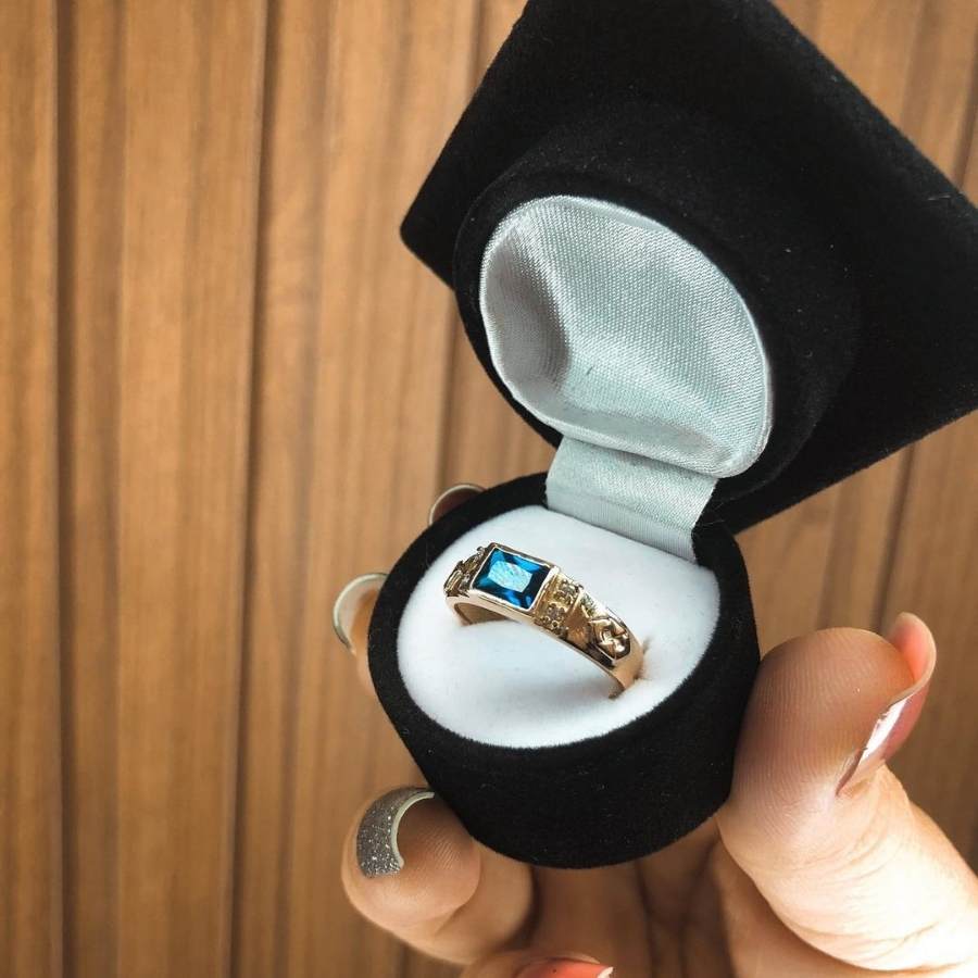 Anel de formatura Administração com pedra safira azul dentro de caixa de veludo em formato de chapéu de formatura