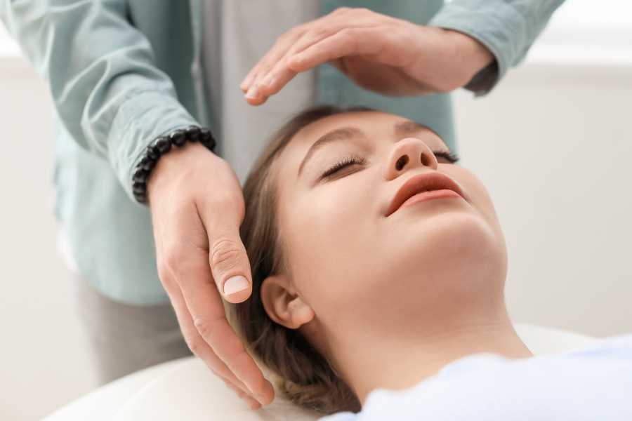 Foto de mulher fazendo sessão de reiki.