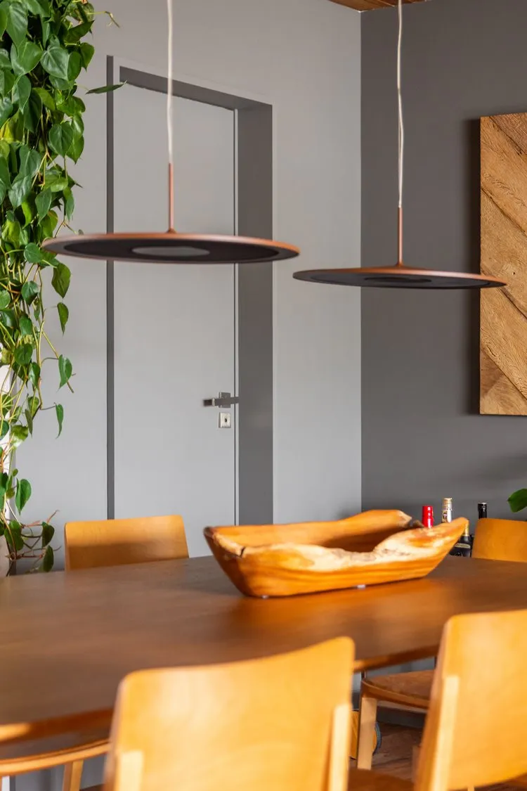 Sala de jantar de apê de 187 m² decorada pelo arquiteto Pietro Terlizzi, foto ampliada em objeto de coração na mesa, uma vasilha rústica de madeira