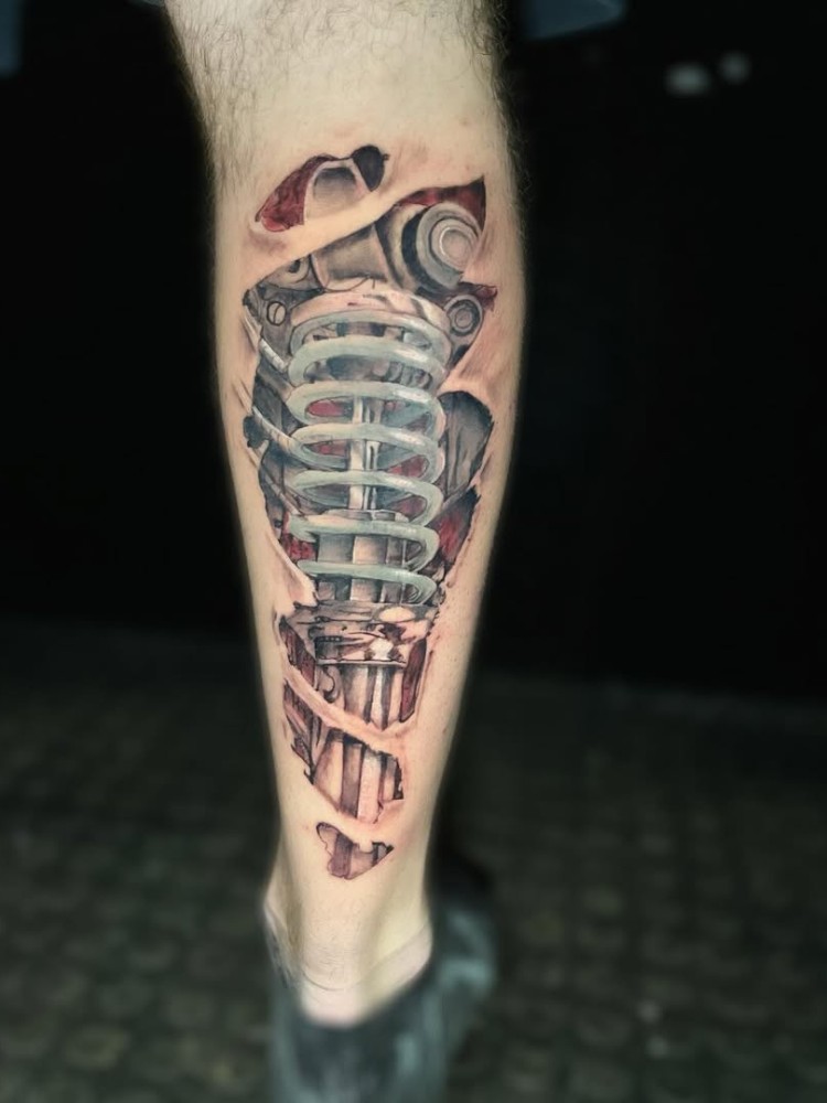 Perna com tatuagem 3D de mola como ferida 