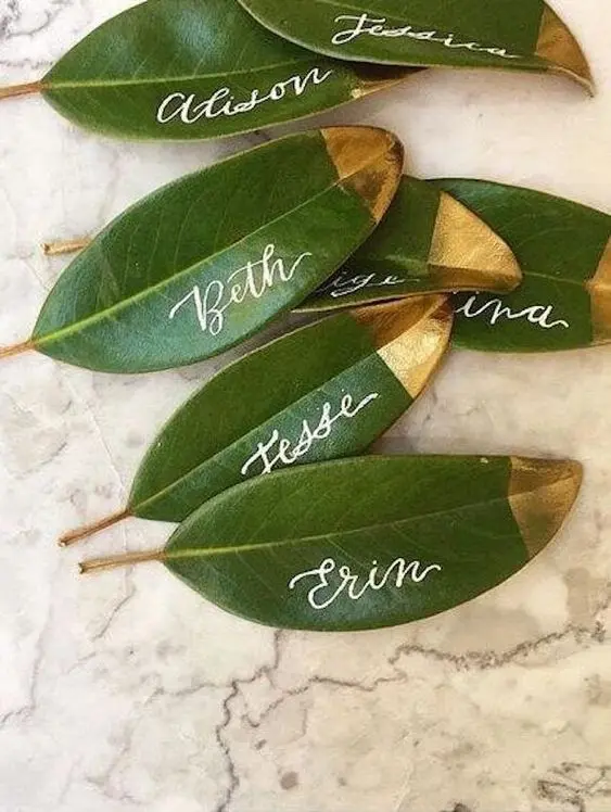 Folhas verdes com nomes escritos e pontas douradas