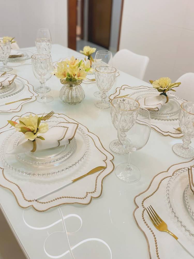 Mesa posta em tons de branco com flores amarelas