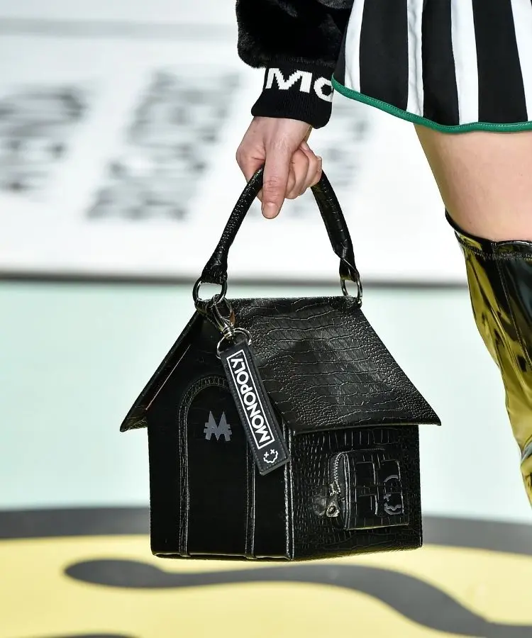 Foto de bolsa de couro preta que imita casinha do Monopoly