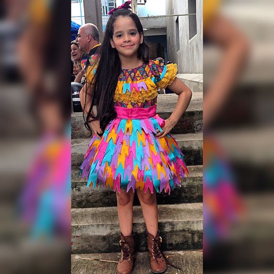menina com vestido de chita e saia com bandeirinhas de fita para sao joão