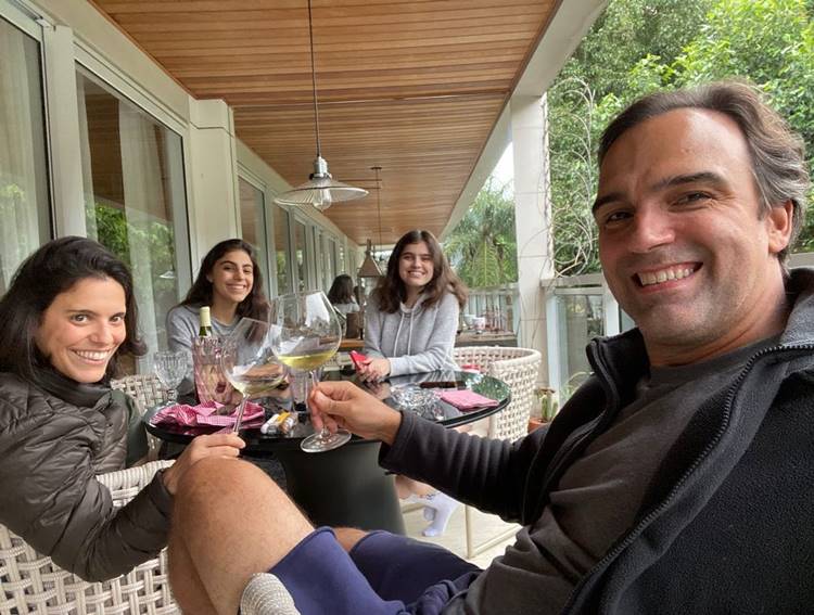 Selfie da família de Tadeu Schmidt à mesa, com esposa e as duas filhas