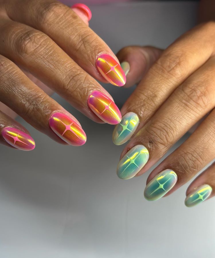 A imagem destaca unhas de carnaval com um design brilhante e chamativo. Cada unha apresenta um efeito furta-cor em tons de rosa, laranja, verde e azul, com um detalhe luminoso central, criando um visual festivo e cheio de personalidade.