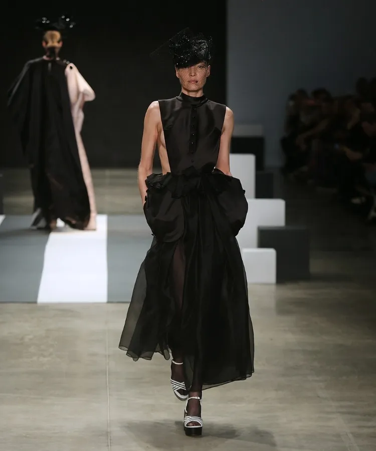 Foto de modelo na passarela usando vestido longo preto