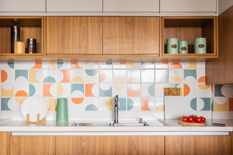 Cozinha com móveis em madeira e azulejos geométricos coloridos 