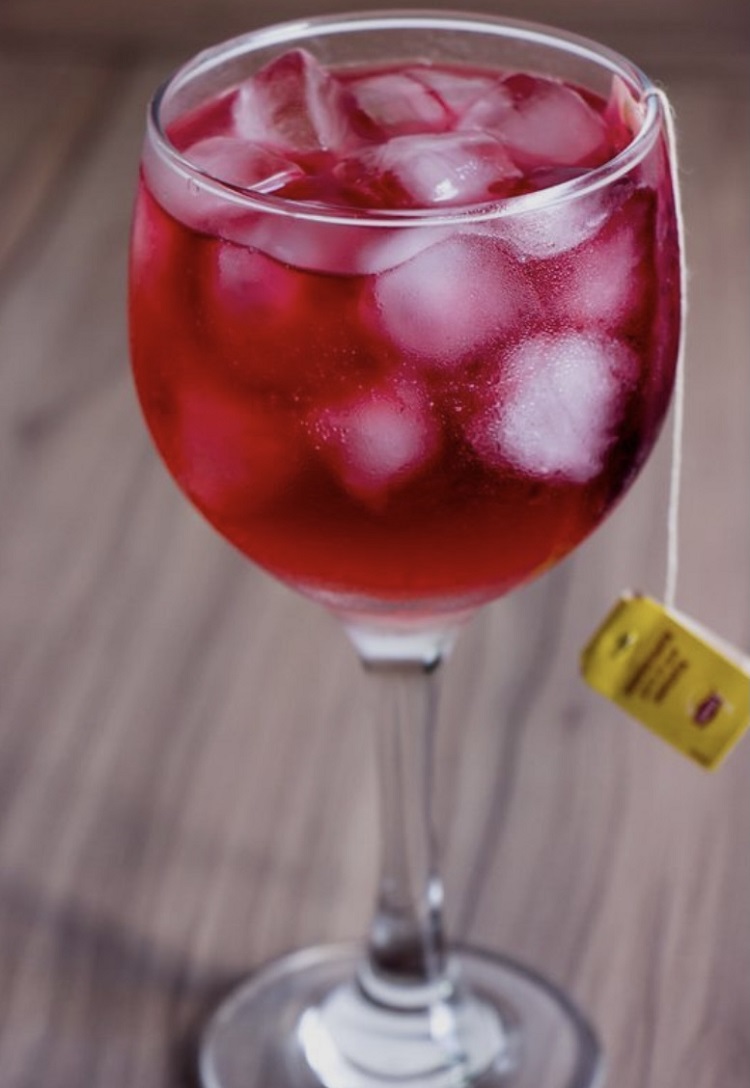 Uma taça do drink diferente que é feito com Gin e chá de frutas vermelhas. Gin com chá de frutas vermelhas