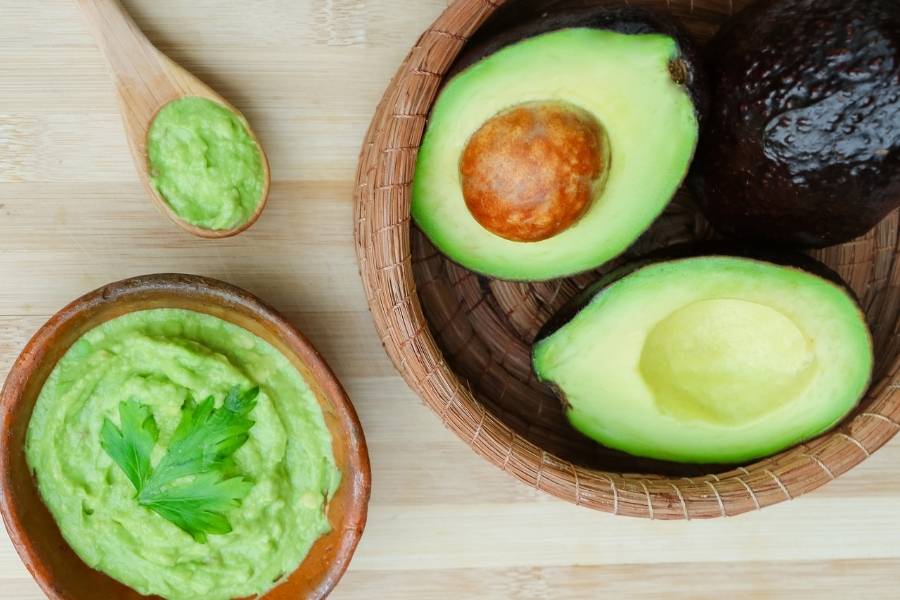 cesta com abacates ao lado de pote de guacamole