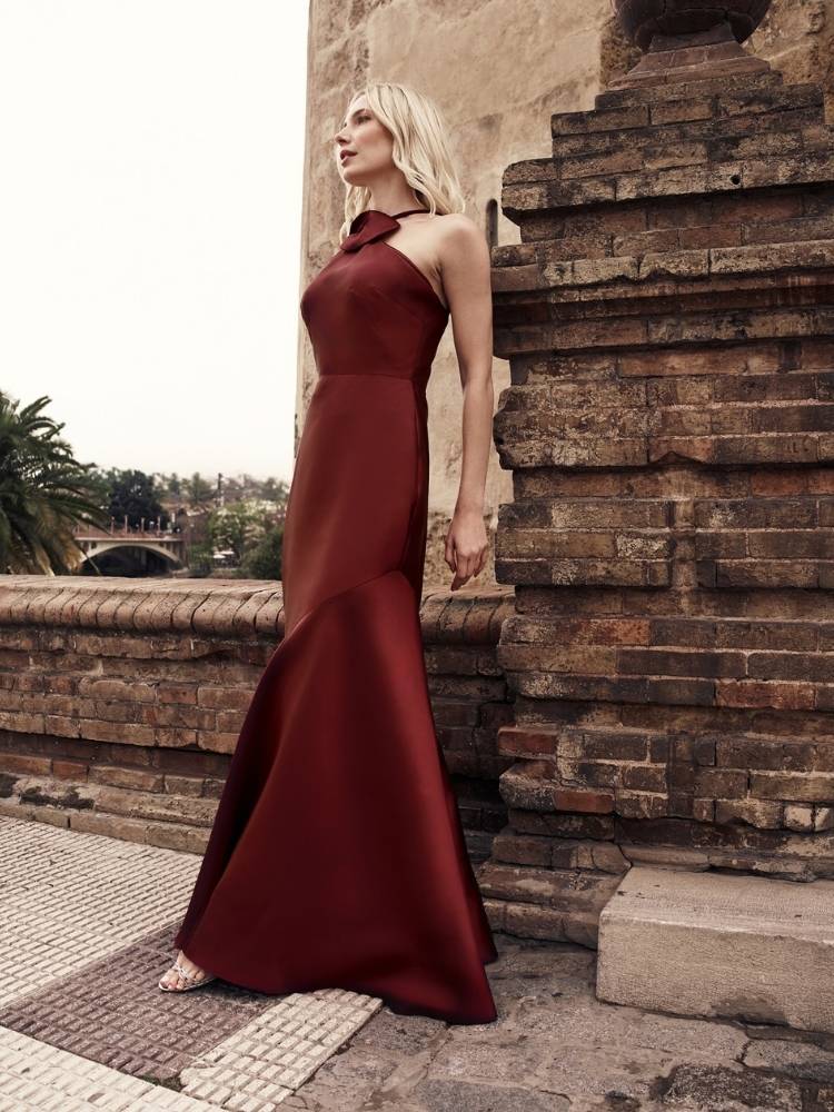 Mulher loira de pele clara com vestido marrom liso de cetim 