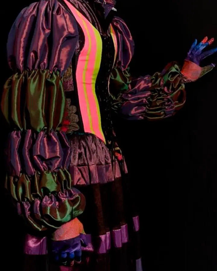 Vestido roxo, verde e rosa com mangas bufantes e teatrais.