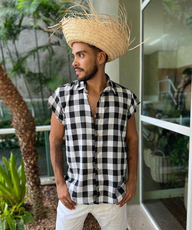 Homem com camisa xadrez preto e branco e chapéu de palha