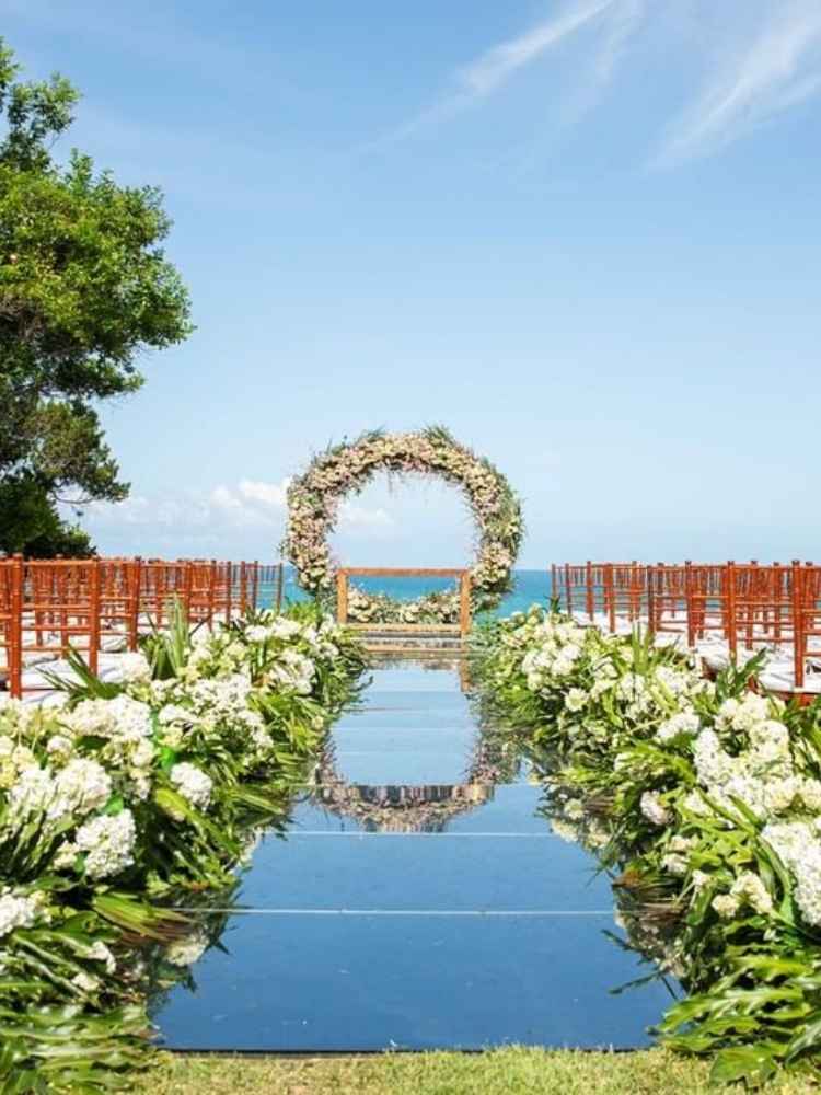 Decoração de casamento passarela de espelho com flores brancas.