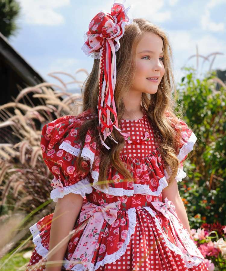 Menina com vestido vermelho de festa junina e adereço no cabelo