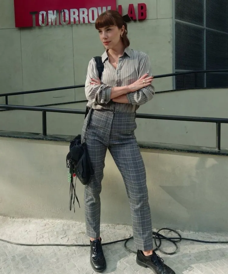 Foto de Alice Wegmann em cena usando um dos looks da Solange Duprat em Vale Tudo, camisa e calça xadrez cinza