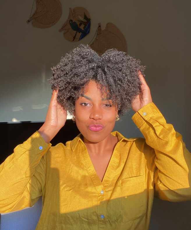 Corte assimétrico mulher com cabelo castanho crespo