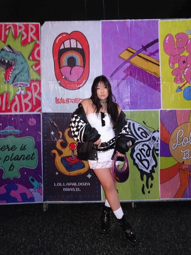 Mulher de origem asiática usando conjunto branco de renda, jaqueta preta over, mix de cintos