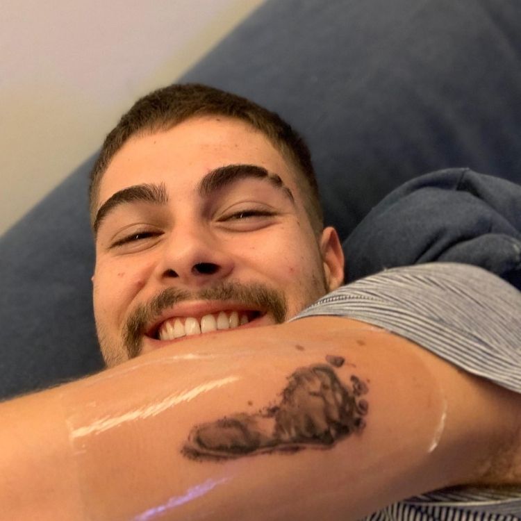 Rafa Vitti mostrando tatuagem do pé da Maria Clara que fez em seu braço