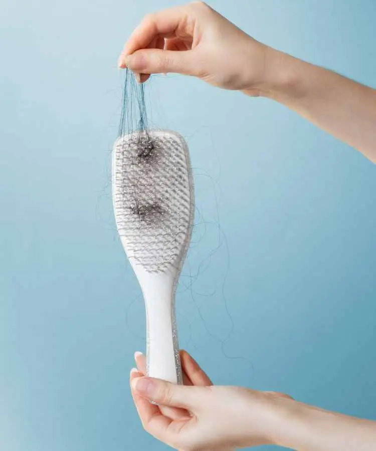 escova de cabelo branco com vários fios preso