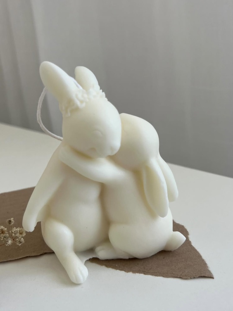 Vela branca de dois coelhos abraçados