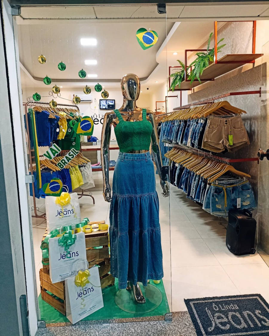 Manequim com saia jeans e cropped verde.